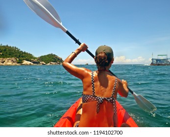 Young girl paddling a kayak in a tropical ocean in summer. - Shutterstock ID 1194102700