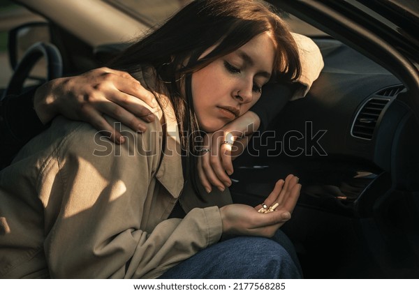 a young girl, a passenger in a car, has a\
handful of psychotropic and painkillers in her hand, she has mental\
problems, fears and phobias,\
pains.