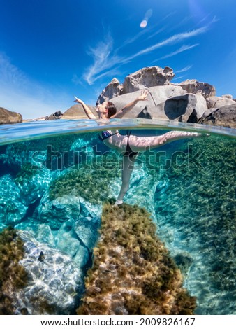 Similar – Unbekannter Jugendlicher in Neoprenanzug und Schnorchel im klaren Wasser mit felsigen Klippen von Menorca, Spanien, geteilter Blick über und unter der Wasseroberfläche