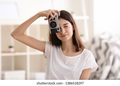 Young girl with photo camera at home