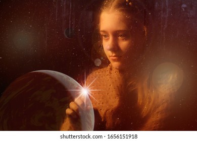 A young girl with piercing eyes behind tinted glasses against the background of the galaxy.The finger points to a shining star.The concept of clairvoyance. Elements of this image are provided by NASA.