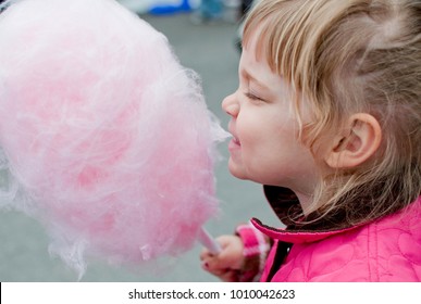 Young Girl In Pink Coat Eats Pink Cotton Candy