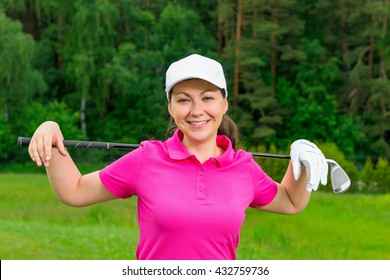 Young Girl In A Pink Shirt And A White Baseball Cap With A Golf Club