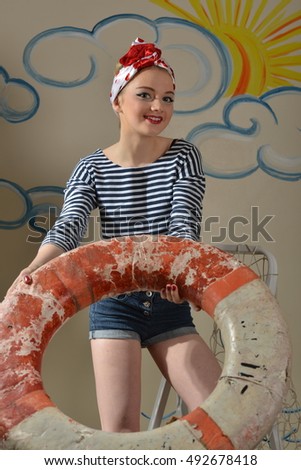 Young girl in pin-up image. A girl holding a life buoy.