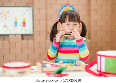 Young Girl Play Harmonica At Home For Homeschooling