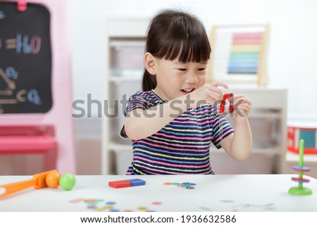 young girl  play magical magnet experiments at home for home schooling