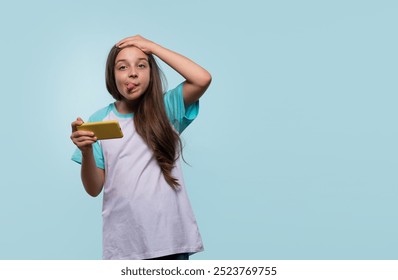 Young girl playfully making a silly face while using a smartphone. - Powered by Shutterstock