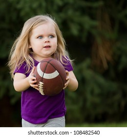 Young Girl Playing In The Backyard Running With Her Football