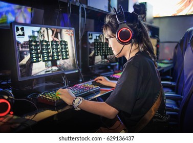 young girl playing computer games in internet cafe