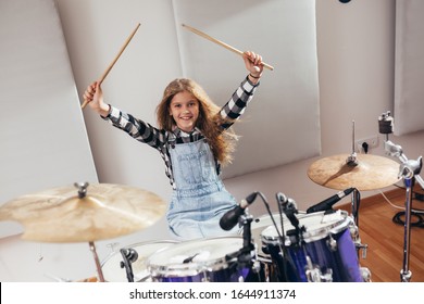 Young Girl Playing Drums In Music Studio