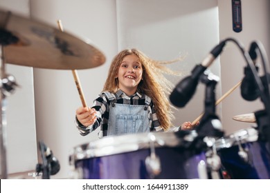 young girl playing drums in music studio