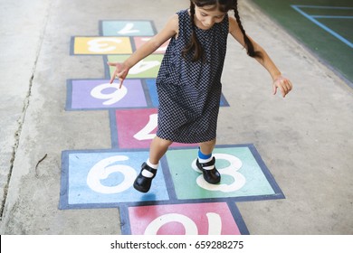 Young Girl Playing Hopscotch