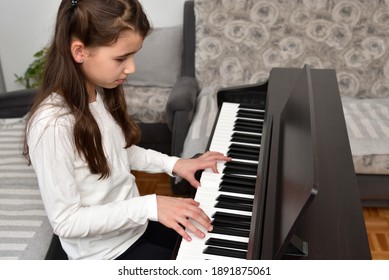 Young Girl Playing The Piano. Child Practicing On The Modern Electric Piano At Home. Music Lesson. 