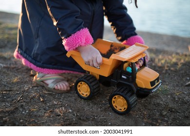 A Young Girl Playing With A Pick Up Truck Toy