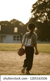 Young Girl Playing Softball In The Evening