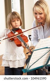 Young Girl Playing Violin In Music Lesson