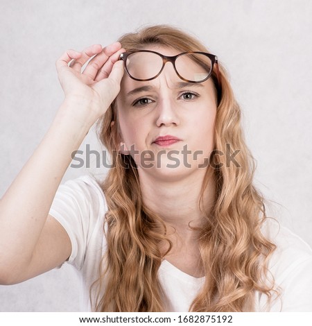 Young girl portrait with glasses making funny faces on white background