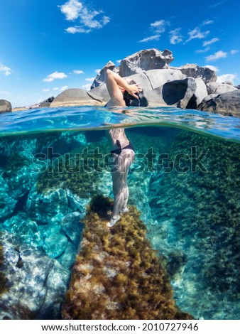 Similar – Unbekannter Jugendlicher in Neoprenanzug und Schnorchel im klaren Wasser mit felsigen Klippen von Menorca, Spanien, geteilter Blick über und unter der Wasseroberfläche