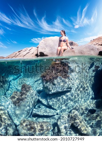 Similar – Unbekannter Jugendlicher in Neoprenanzug und Schnorchel im klaren Wasser mit felsigen Klippen von Menorca, Spanien, geteilter Blick über und unter der Wasseroberfläche