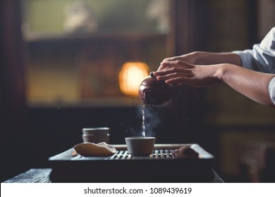 Young girl pouring tea from teapot close-up