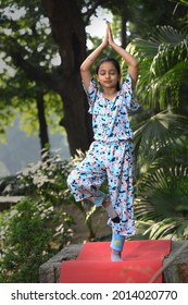 A Young Girl Practicing Early Morning Yoga Asana In The City Park 