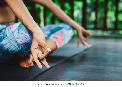 Young girl practicing yoga and meditation during vacation yoga retreat in Bali, fingers in mudra