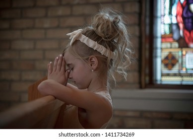 little girl praying in church