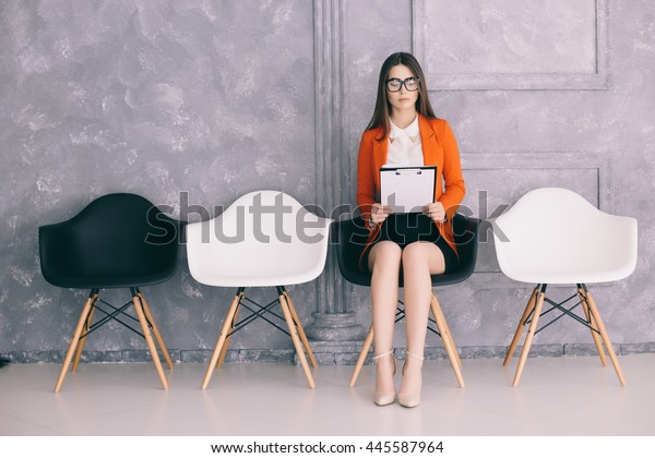 Young\
girl is preparing for first job interview in\
hall
