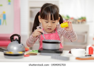 Young  Girl Pretend Play Food Preparing At Home