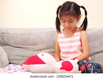 A Young Girl Pretending To Be A Nurse And Taking Care Of Her Stuffed Animal