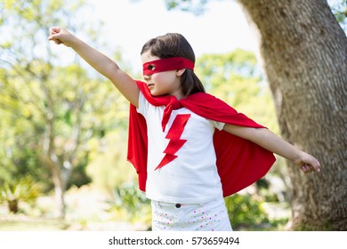 Young girl pretending to be a superhero in park - Powered by Shutterstock