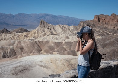 a young girl in profile taking photos of the desert landscape in Dead Valley Desert - Powered by Shutterstock