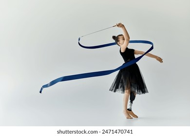 A young girl with a prosthetic leg gracefully performs a ribbon routine in a gymnastics studio. - Powered by Shutterstock