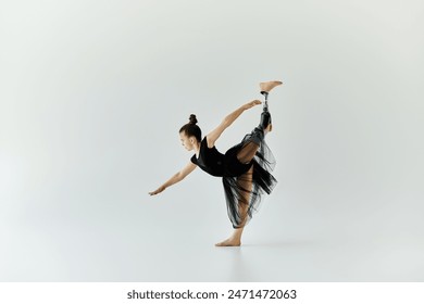 A young girl with a prosthetic leg performs a graceful stretch in a studio. - Powered by Shutterstock