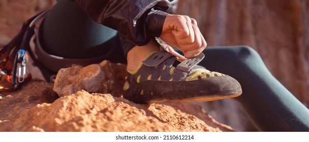 A young girl puts on special climbing shoes on her legs before climbing outdoor training, hands and feet close-up. A woman leads an active lifestyle, is involved in mountaineering and rock climbing. - Powered by Shutterstock