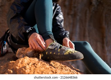 A Young Girl Puts On Special Climbing Shoes On Her Legs Before Climbing Outdoor Training, Hands And Feet Close-up. A Woman Leads An Active Lifestyle, Is Involved In Mountaineering And Rock Climbing.