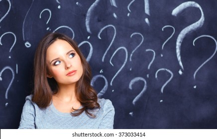 Young Girl With Question Mark On A Gray Background