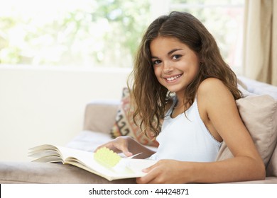 Young Girl Reading Book At Home