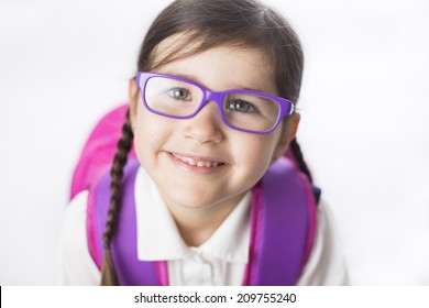 Young girl is ready to start school in a uniform wearing a backpack. 
