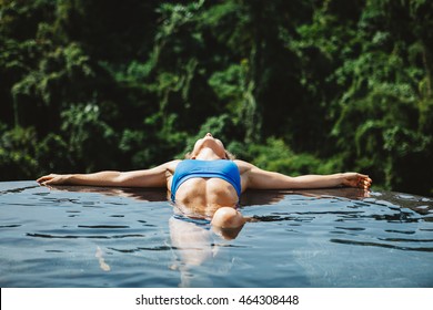 Young Girl Relaxing In The Pool With Jungle View During Yoga Retreat Vacation In Bali