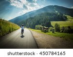 Young girl riding her bicycle along the street that from San Candido,Italy, leads to Leinz, Austria