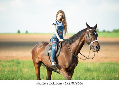 Young girl riding on a brown horse 