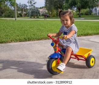 Young Girl Riding Tricycle