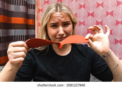 Young Girl Ripping Valentine's Day Heart In Two Pieces. Women Sad Ripping Paper In Two Pieces. European Women Sad.