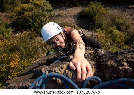 Young girl rockclimbing - reaching the summit, Pikovice, Czech republic
