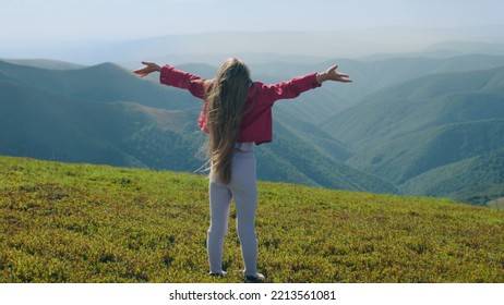 Young Girl Running On Beautiful Greenery Hill And Moves Long Hair, Enjoying Flows Of Warm Wind, Spending Leisure Time Outdoor. Back View. Slow Motion.