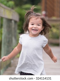 Young Girl Running On Dock, With A Big Smile.