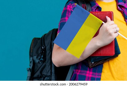 Young Girl With School Stuff Holds In Hand Ukraine Flag Close Up