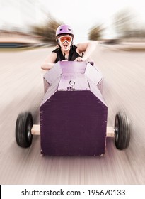 Young Girl Screaming As She's Rolling Down A Hill In A Homemade Soap-box Car