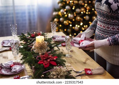 Young girl setting up dining table decorated for Christmas